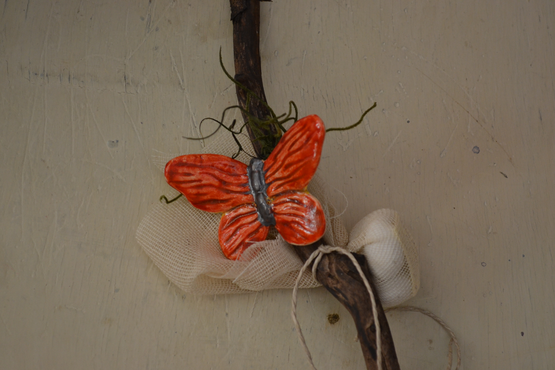 Μπομπονιέρα με κεραμική πεταλούδα, γάζα και κλαδιά 
